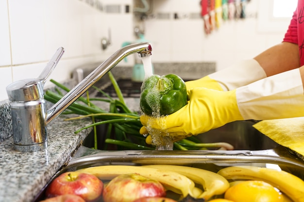 Reinigung von Obst und Gemüse mit Latexhandschuhen gegen Coronavirus