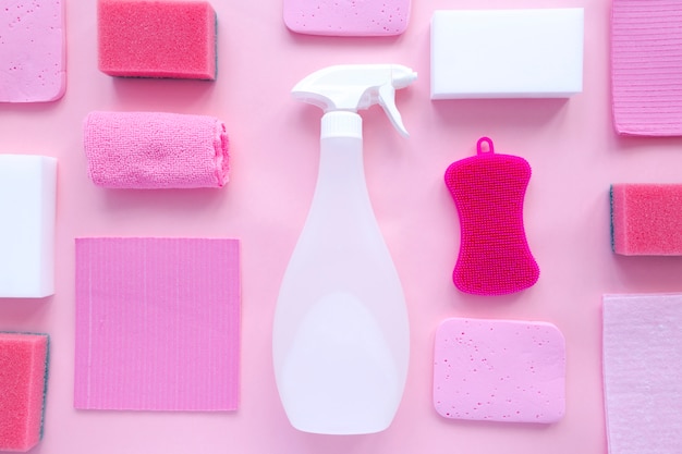 Reinigungsmittel und Reinigungsmittel, Schwämme, Servietten und Gummihandschuhe, rosa Hintergrund.