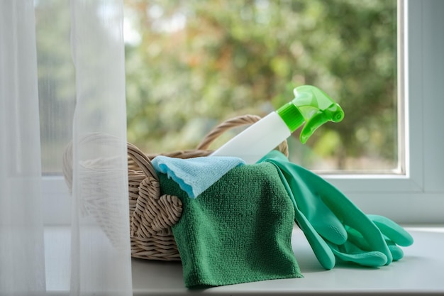 Reinigungsmitteltücher und Gummihandschuhe in einem Korb auf der Fensterbank Allgemeines Reinigungskonzept