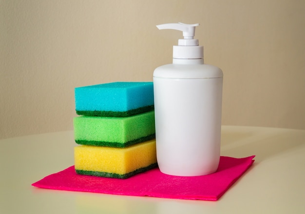Reinigungsprodukt Shampoo und Waschlappen auf roten Tüchern zum Abstauben. Der Reiniger sorgt für Hygiene im Haus
