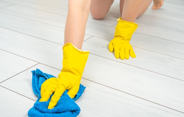 Reinigungsservice Abgeschnittene Aufnahme einer jungen Frau, die weißen Boden mit blauem Tuch putzt Reinigungsservice-Konzept Young Maid Cleaning Floor Fröhlicher Reinigungsservice Kopierraum