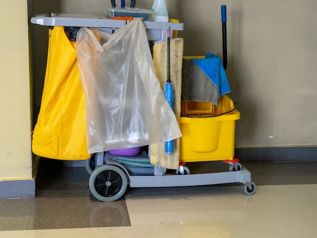 Reinigungswerkzeugwagen warten auf Reiniger. Becher und Reinigungsgeräte im Büro.