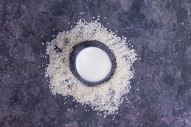 Reis vegane Milch in einer Glasschale mit Reis auf einem grauen Hintergrund