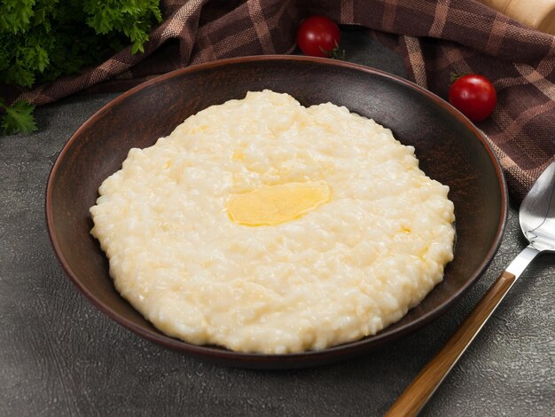 Reisbrei mit Milch und Butter auf einem dunklen Teller