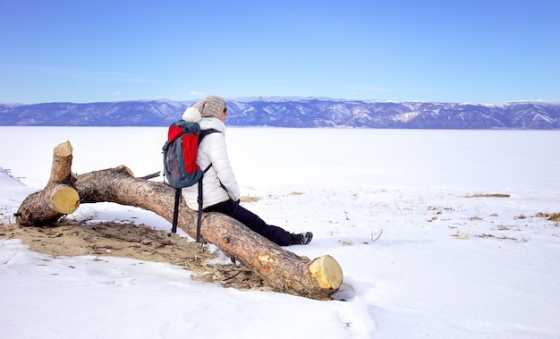 Reise-Konzept. Weiblicher Wanderer mit enjoing Ansicht des Rucksacks vom Baikalsee, Sibirien, Russland. Wintertourismus.