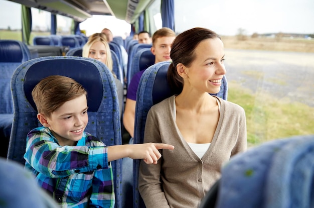 reise-, tourismus-, familien-, technologie- und menschenkonzept - glückliche mutter und sohn fahren im reisebus