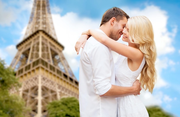 reise, tourismus, menschen, liebe und datierungskonzept - glückliches paar, das über eiffelturm im pariser hintergrund umarmt