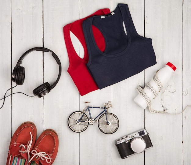 Reise- und Sportkonzept Fahrradmodell Schuhe Hemden Kopfhörer Kamera Flasche Wasser und Zentimeter Klebeband