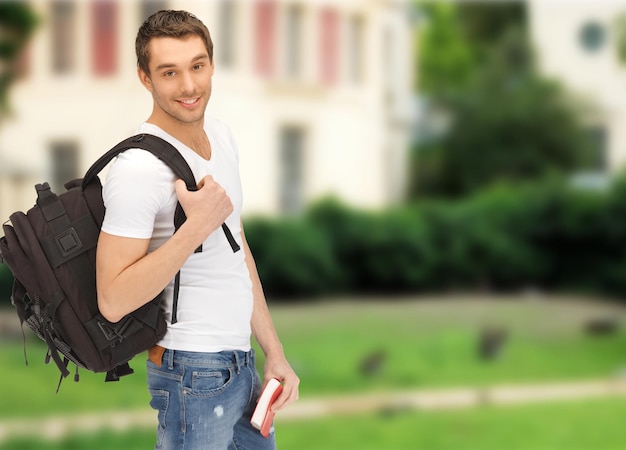 reise-, urlaubs- und bildungskonzept - reisender student mit rucksack und buch