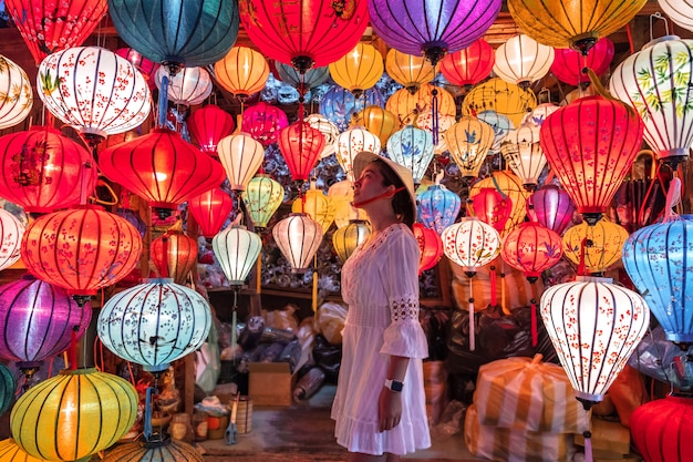 Reisefrau, die Laternen in Hoi An, Vietnam wählt