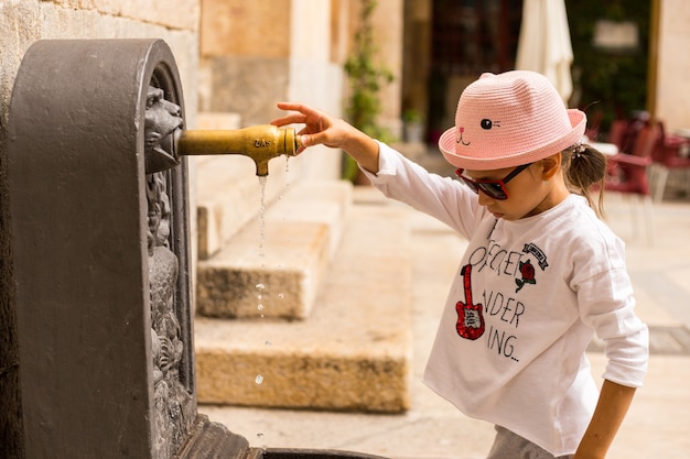 Reisemädchen in der Altstadt nahe mittelalterlichem Wasserhahn