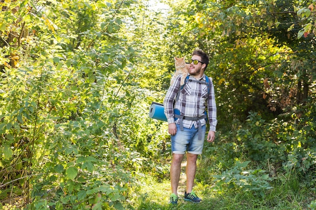 Reisen, Abenteuer, Wanderung, Tourismus und Naturkonzept - Tourist mit Katze im Wald spazieren