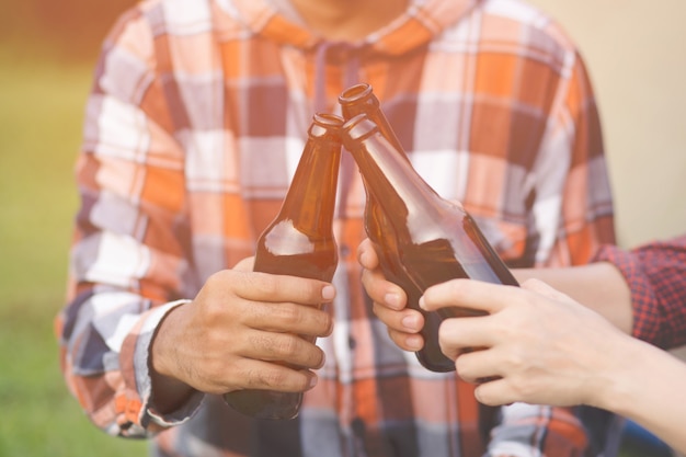 Reisen drei junge Freunde zusammen Spaß haben Entspannen Sie sich im Wandercamp und trinken Sie Bier Cheers Flaschen