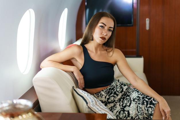 Reisen und Technik fliegen erster Klasse eine hübsche junge Geschäftsfrau sitzt im Flugzeug