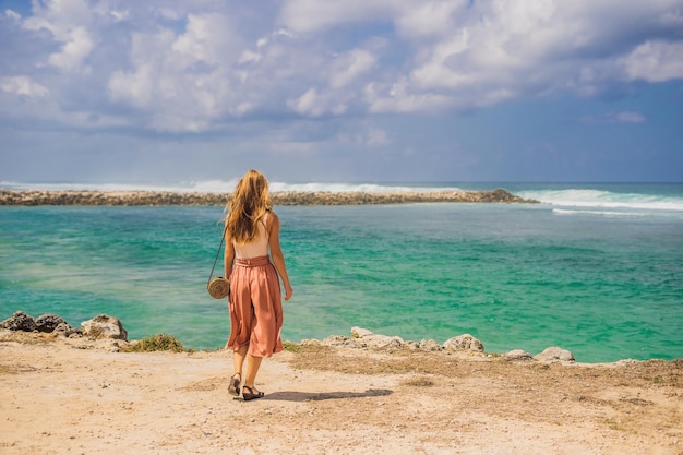 Reisende der jungen Frau auf erstaunlichem Melasti-Strand mit türkisfarbenem Wasser, Bali-Insel Indonesien