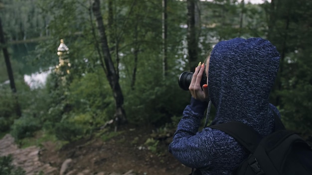 Reisende, die malerische Aussicht im Wald fotografieren Eine kaukasische Frau, die einen schönen magischen Blick schießt Mädchen macht ein Fotovideo auf einer spiegellosen DSLR-Kamera Professionelle Fotografen reisen mit Rucksack im Freien