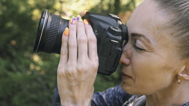 Reisende, die malerische Aussicht im Wald fotografieren Eine kaukasische Frau, die Nahaufnahmen schießt, sieht aus Mädchen machen ein Fotovideo auf einer spiegellosen DSLR-Kamera