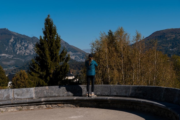 Reisende Frau, die mit ihrem Handy die Berge in Saint Savin Frankreich fotografiert?