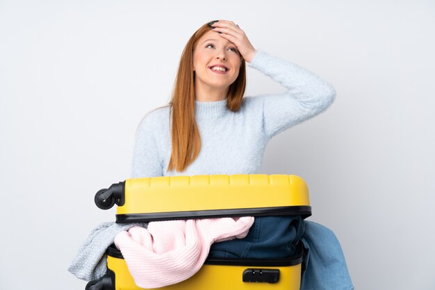 Reisende Frau mit einem Koffer voller Kleider lachen