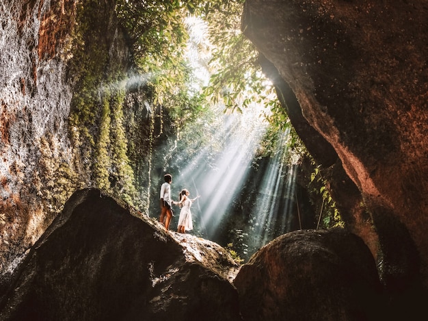 Reisende junge Paare mit tropischem Regenwaldfelsen in Bali