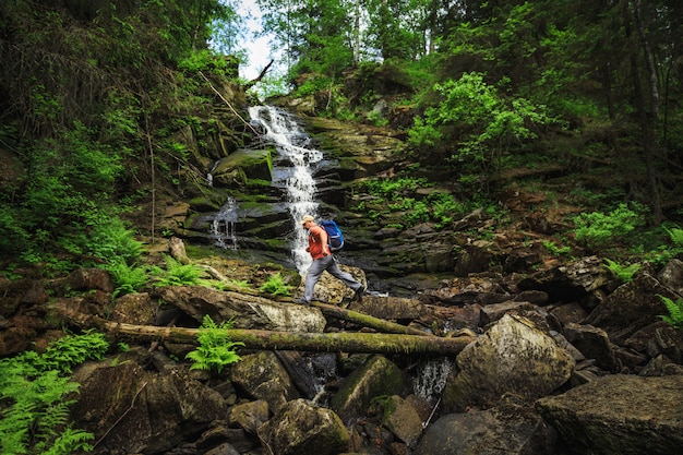 Reisende mit einem Rucksack überqueren den Fluss.