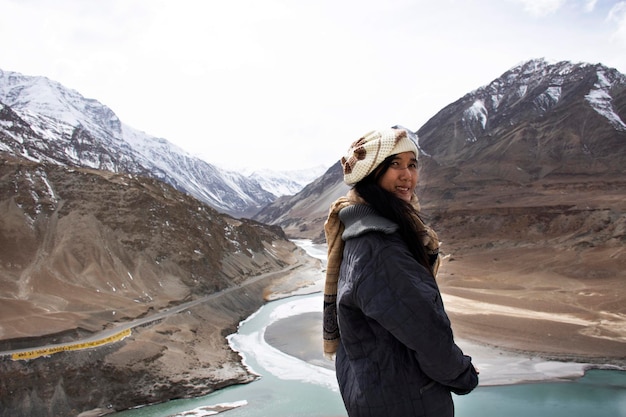 Reisende thailändische Frau besucht und posiert für ein Foto am Aussichtspunkt des Zusammenflusses der Flüsse Indus und Zanskar während der Wintersaison in Leh Ladakh in Jammu und Kaschmir Indien