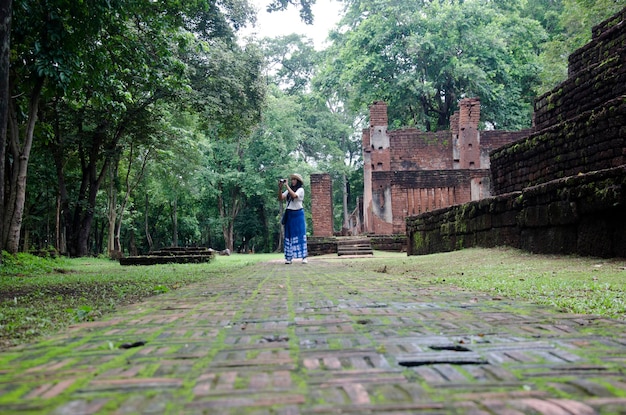 Reisende thailändische Frau zu Fuß besuchen und reisen fotografieren in alten Gebäuden und Ruinen des Kamphaeng Phet Historical Park ist eine archäologische Stätte und das Aranyik-Gebiet in Kamphaeng Phet Thailand