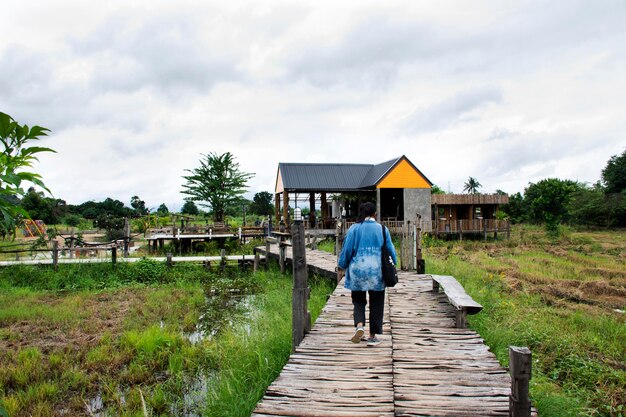 Reisende thailändische Frauen, die auf der Holzbrücke zu Fuß unterwegs sind, gehen zum Café, Café und Restaurant in den Sehenswürdigkeiten KaoNor KaoKaew Kalksteinberg in der Stadt Banphot Phisai in Nakhon Sawan Thailand