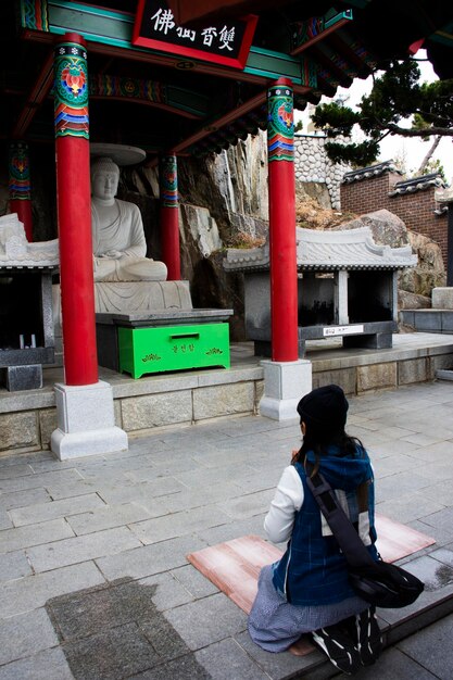 Reisende thailändische Frauen reisen besuchen und respektieren betenden Segen wünschen heiliges Geheimnis alten Steinbuddha im Tempel Haedong Yonggungsa in Gijang am 18. Februar 2023 in Busan oder Pusan oder Pusan Südkorea