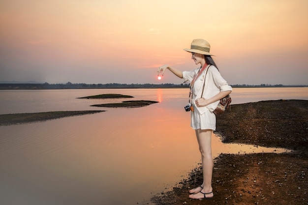 Foto reisende tragen freizeitkleidung bei sonnenuntergang am ruhigen see entspannen