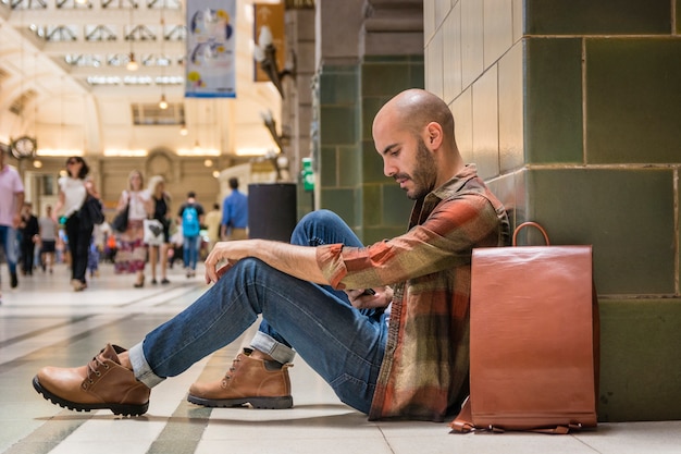 Foto reisender, der auf u-bahnboden sitzt