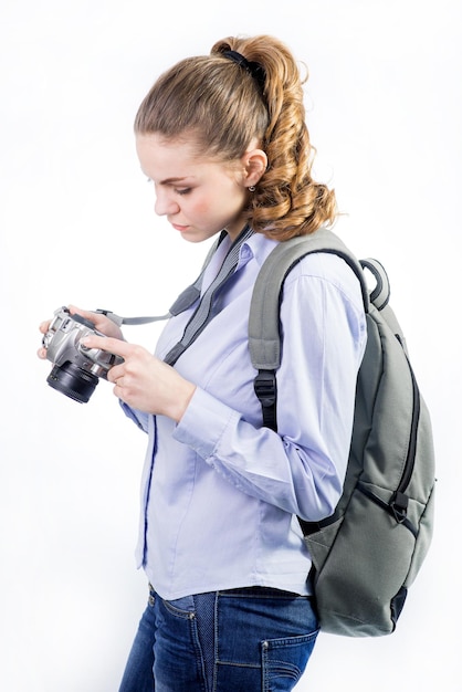 Foto reisender der jungen frau mit kamera und tragendem rucksack auf weißem hintergrund