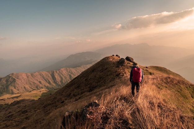 Reisender des jungen Mannes mit Rucksacktrekking auf Berg