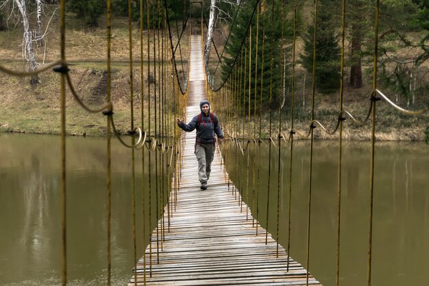 Reisender geht entlang der Hängebrücke über den Quellfluss