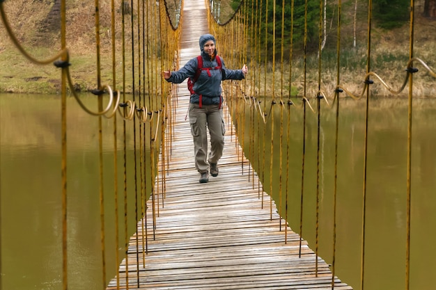 Reisender geht entlang der Hängebrücke über den Quellfluss