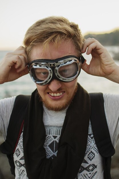 Foto reisender junger mann an der küste in schutzbrillen