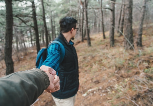 Reisender Mann im Wald, der Hand hält