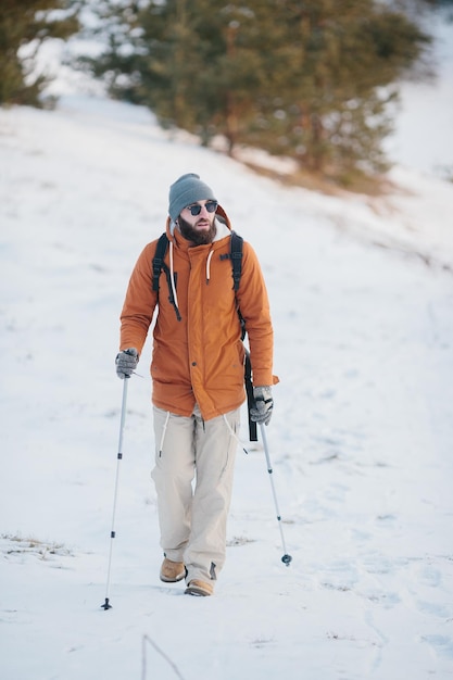 Reisender Mann mit Rucksack Wandern im Winter verschneite Waldlandschaft Reisen Lifestyle Konzept Abenteuer Aktivurlaub Outdoor kaltes Wetter in die Wildnis