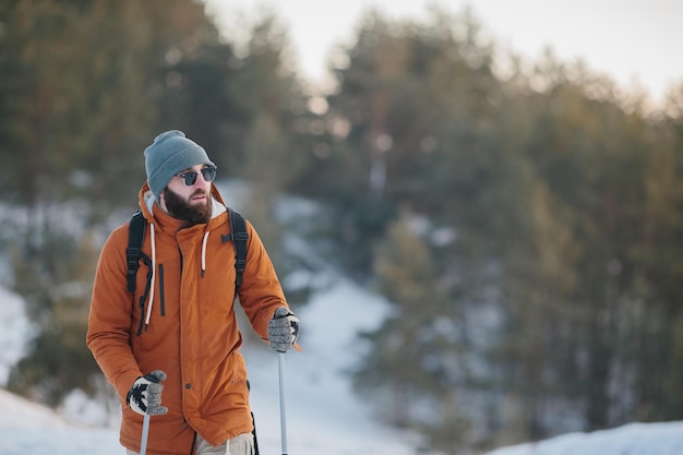 Reisender Mann mit Rucksack Wandern im Winter verschneite Waldlandschaft Reisen Lifestyle Konzept Abenteuer Aktivurlaub Outdoor kaltes Wetter in die Wildnis