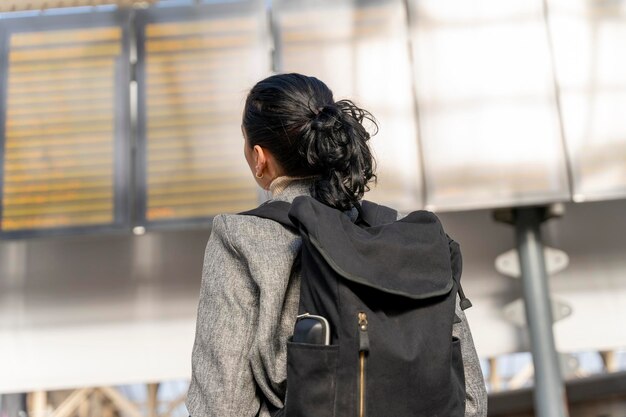 Reisender mit einem Rucksack, der am Bahnhof auf einen Zug wartet Reisekonzept