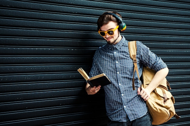 Reisender Student mit Rucksack und Buch. Reisekonzept