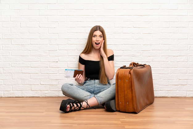 Reisendfrau mit Koffer und Bordkarte mit Überraschung und entsetztem Gesichtsausdruck