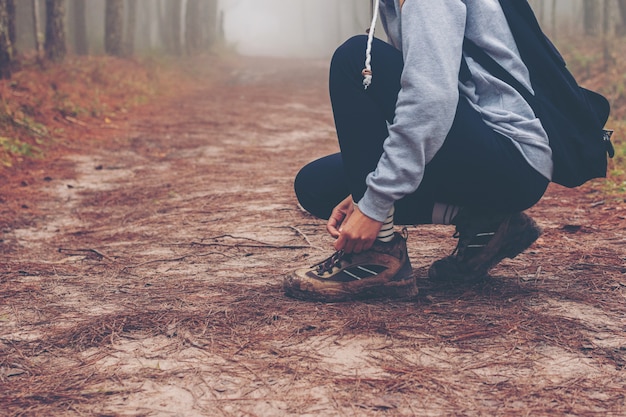 Reisendfrauen, die auf Straße in den Waldwegen im Wald und im nebeligen gehen