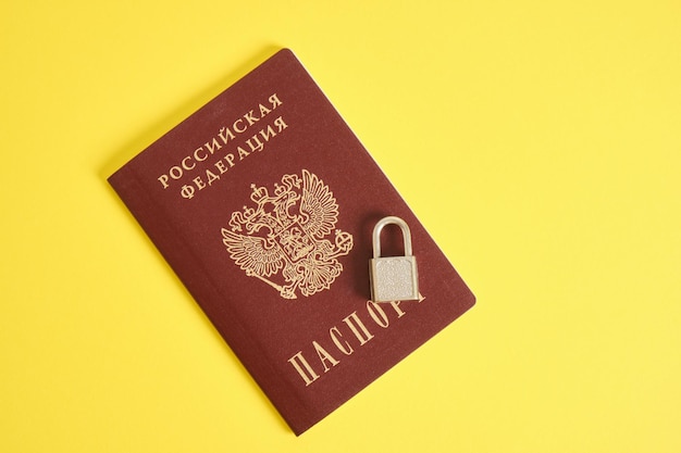 Reisepass der Russischen Föderation und ein Schloss auf gelbem Hintergrund