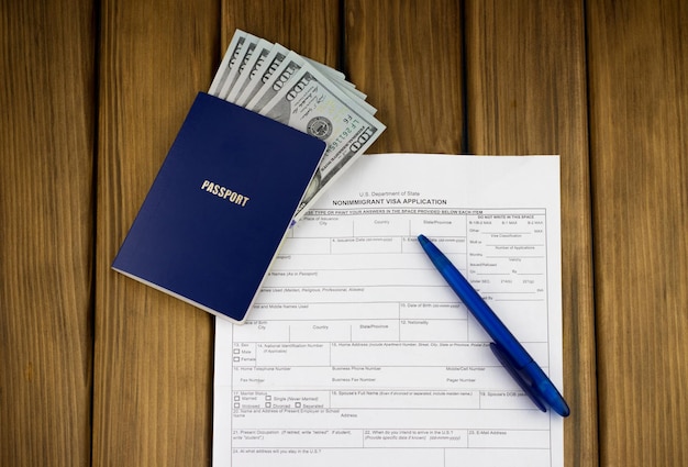 Reisepass mit Geld und Visumantragsformular auf dem Tisch