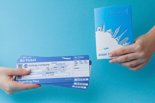 Foto reisepass und flugticket in frauenhand auf blauem hintergrund kopierbereich für das reisekonzept