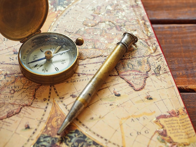 Reiseplanung Alte Kompasskarte und Stift auf Holzuntergrund