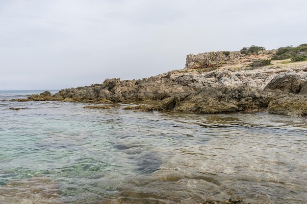 Reisesommer, Mittelmeer, das gegen die Felsen der spanischen Insel Mallorca, Ibiza, Spanien stürzt.