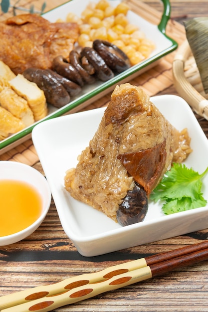 Reisknödel ist ein traditionelles chinesisches Reisgericht, das aus Klebreis besteht und in Bambusblätter gewickelt wird. Beim Dragon Boat Festival wird Zongzi mit der Familie zubereitet und gegessen