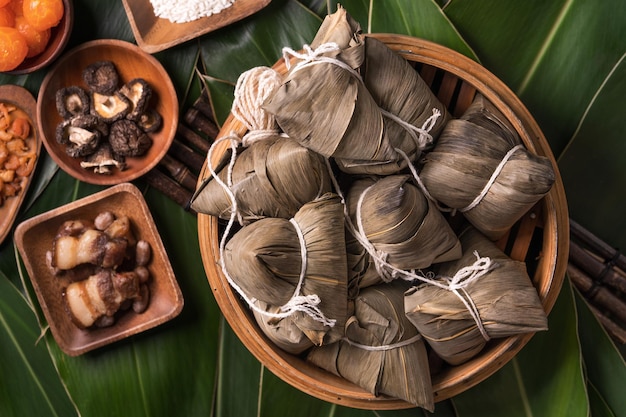 Reisknödel Zongzi Traditionelles chinesisches Essen auf grünem Blatthintergrund des Drachenbootfestivals Duanwu Festival Draufsicht flach lag Designkonzept